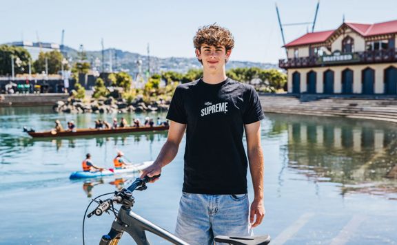 Lachie Ross with a bike next to Whairepo Lagoon.