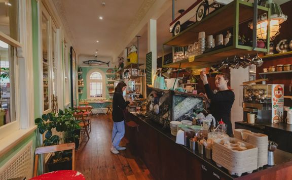 A customer at the counter while the barista makes coffees at The House of Good Fortune.