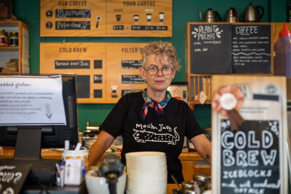 A barista stands behind the counter at the Small Batch flagship café in the heart of Petone.