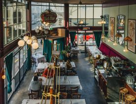 Interior of Le Bouillon Bel Air, a French restaurant in Wellington, featuring high ceilings, large windows, and classic Art Deco bistro decor.