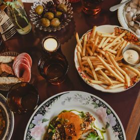 Various plates of food on a table at The Ram, including fries, oysters, olives, salami, and more.