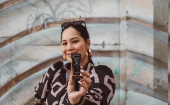 Rawinia Rimene holding a tube of BB cream from her skincare brand, Girl Native.