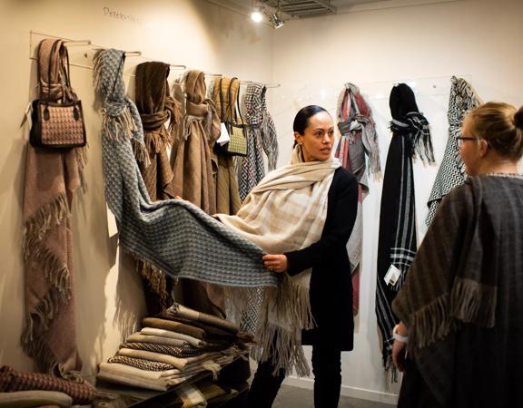 Two people at the Stansborough Mill in Petone shopping for wool scarves. 