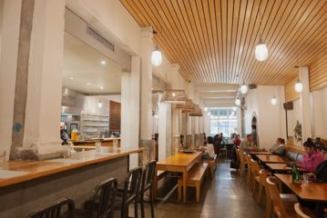 Inside Loretta, a Mediterranean restaurant on Cuba Street. The bright space has high ceilings, a concrete floor, and modern furniture.