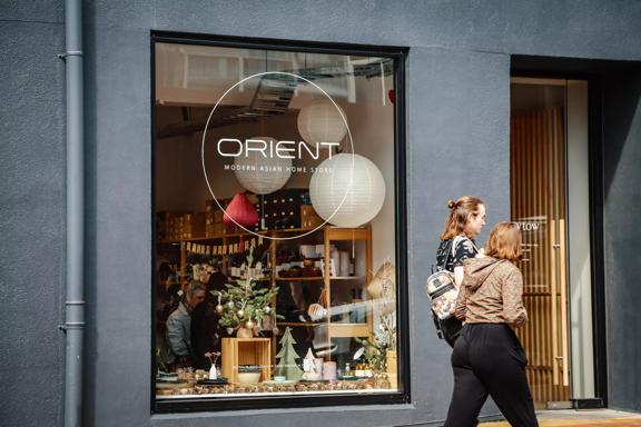 Two people walk by Orient's storefront. Orient Homewares and Gifts is a small gift shop located in Te Aro Wellington.