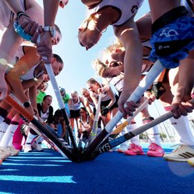 Field hockey players in a huddle.