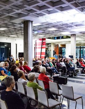 People are seated in the Te Ahumairangi Foyer at a readers and writers event.