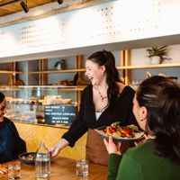Two people dining at Volco on Egmont Street being served their food