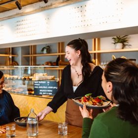 Two people dining at Volco on Egmont Street being served their food