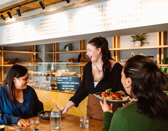 Two people dining at Volco on Egmont Street being served their food