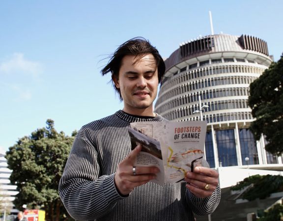 A person doing the Footsteps of Change Wellington Parliamentary Precinct self-guided walking tour with the Beehive building in the background.