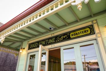 The exterior of The House of Good Fortune with their sign out front.