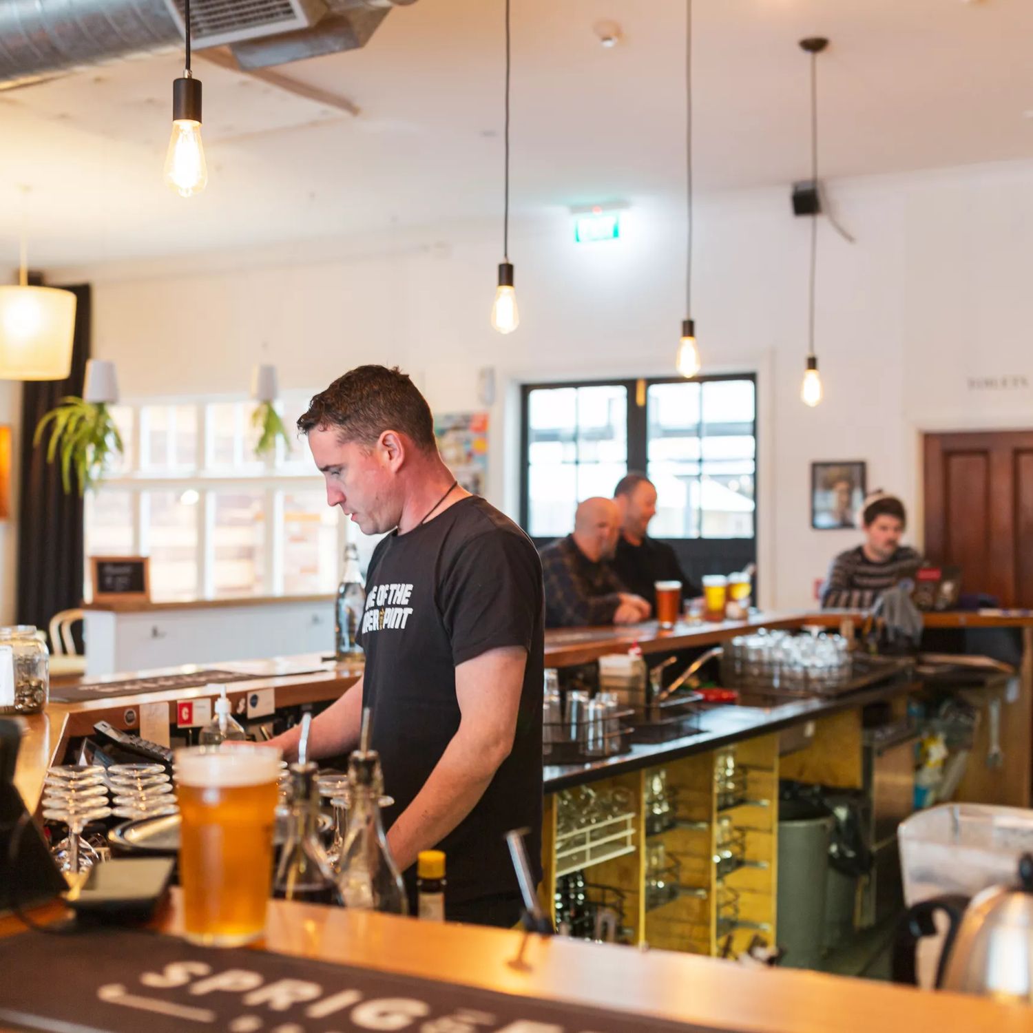 Bar staff inside Sprig + Fern Petone making drinks.