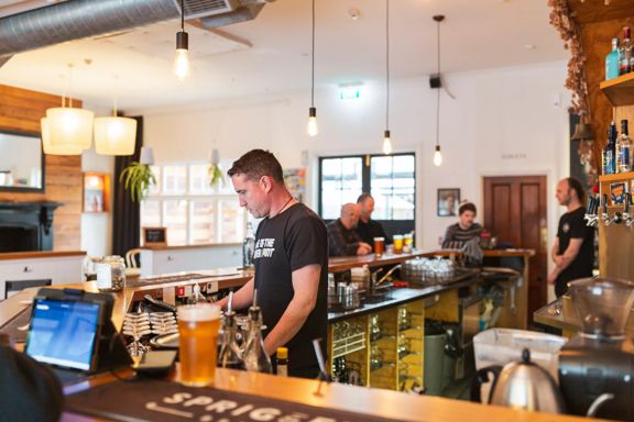 Bar staff inside Sprig + Fern Petone making drinks.