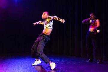 Dancer up on their toes with knees forward and arms outstretched.