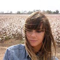A close-up of American singer-songwriter, Charlyn Marie "Chan" Marshall, better known by her stage name Cat Power, looking down in a field.