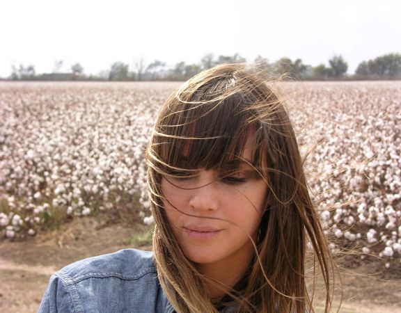A close-up of American singer-songwriter, Charlyn Marie "Chan" Marshall, better known by her stage name Cat Power, looking down in a field.