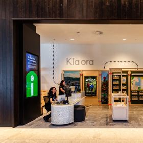 People sit at the information desk of the Wellington isite in Tākina.