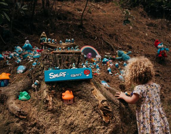 A young child looks at 'the Smurf corner', a manmade fairy village on the Spicer Link Trail.