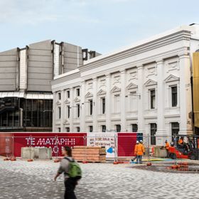 Person walking in front of Te Whare Whakarauika Wellington Town Hall with construction works happening