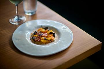 A gourmet dish of tomatoes arranged beautifully on a large white plate.