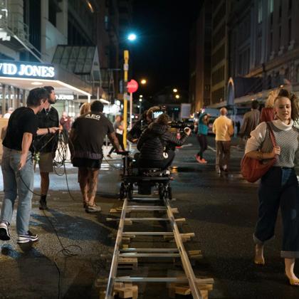 Film crew on a camera dolly track, on Lambton quay.