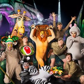 The cast of Madagascar the Musical on stage in costume posing together. 
