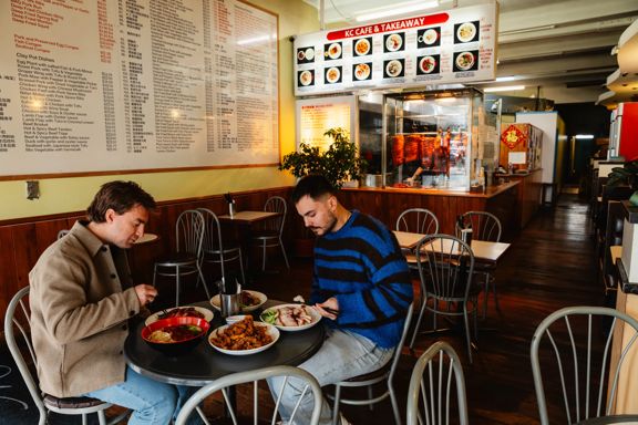 Two friends enjoying asian cuisine at K C Cafe & Takeaway.