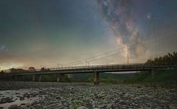 The Tauwharenikau Bridge in Featherston at night, with the Milky Way lighting the sky above it.