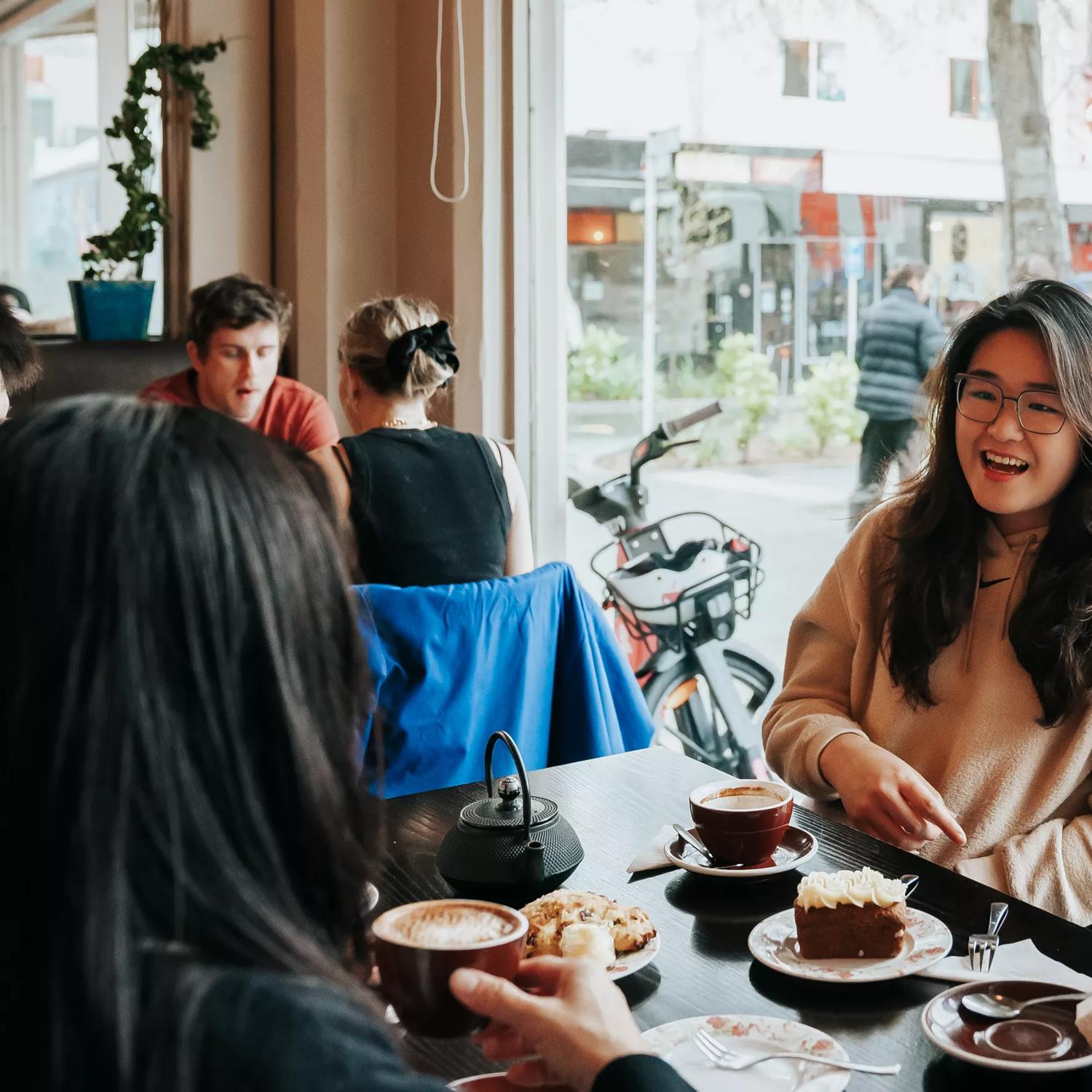 Three friends enjoy coffee and dessert at Floriditas, a restaurant on Cuba Street in Wellington.