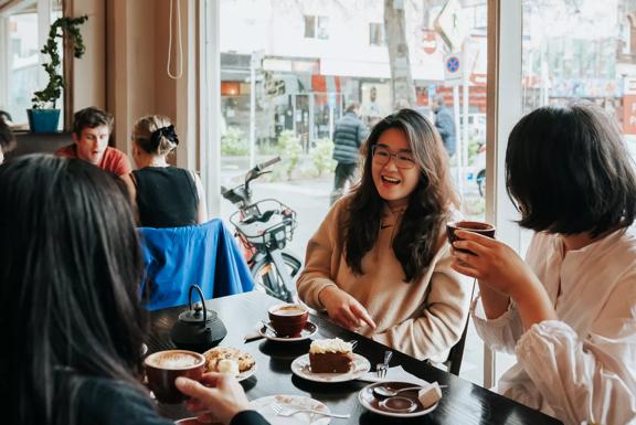 Three friends enjoy coffee and dessert at Floriditas, a restaurant on Cuba Street in Wellington.