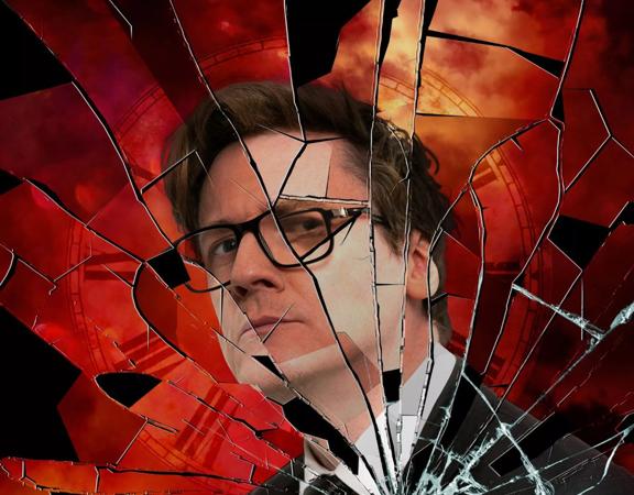 Critically acclaimed comic, Ed Byrne, is returning to Wellington. He is wearing a suit, and square-frame glasses and has a peculiar facial expression. The image has a broken glass texture overlay.