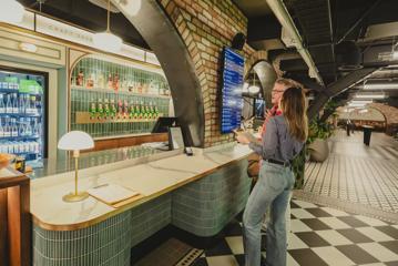 2 people lining up at a counter in Willis Lane, discussing what to order.