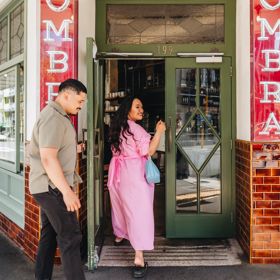 Two people enter the front door of Ombra.