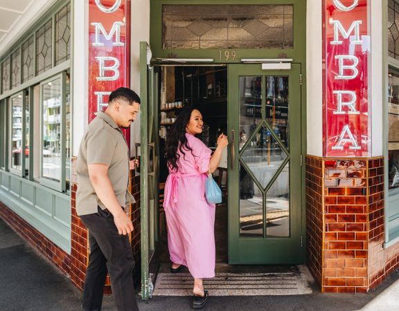 Two people enter the front door of Ombra.