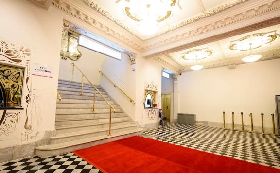 A red carpet leading to the grand marble stairs inside The Opera House.