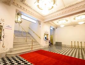 A red carpet leading to the grand marble stairs inside The Opera House.