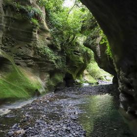 Patuna Chasm, a cave system in a gorge of a river cutting through limestone cliff.