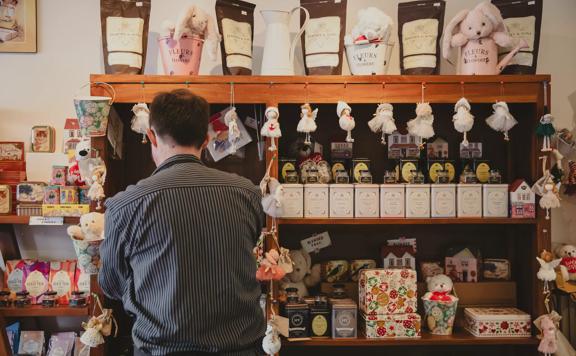 A person facing a shelf inside The Chocolate Story, a chocolate shop located in Petone in Lower Hutt.