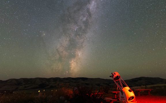 A telescope points toward a brilliant night sky over Wairarapa.