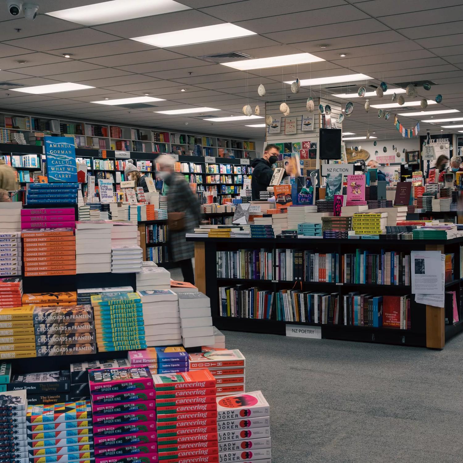 The interior of Unity Books, with shelves and display tables of books.