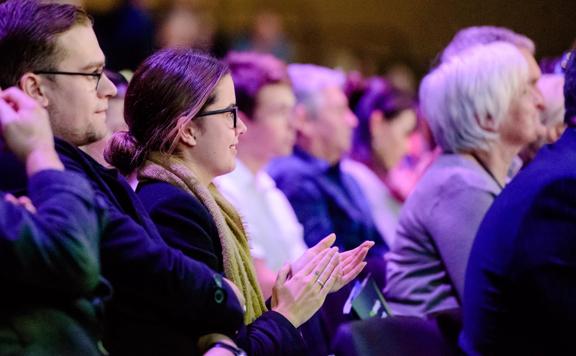 Crowd members clapping at the Harcourts Conference in the TSB arena.