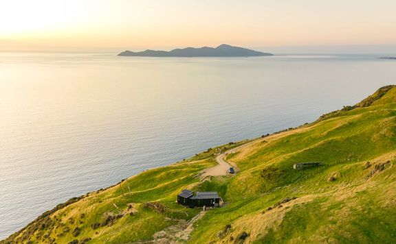 Drone shot above Tunapo Escape, in Paekakākāriki at sunset, with Kapiti Island in the background.
