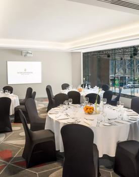 A meeting room looking over Lambton Quay, with 3 circular tables set for a social gathering.