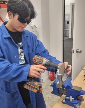 A participant in The Summer of Engineering program working on their Clutterbot project.