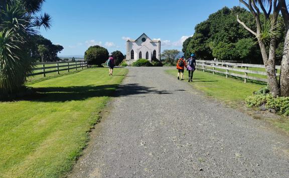 Bikers walking towards The Old Saints Church, Wairongomai, on the Remutaka Cycle Trail.