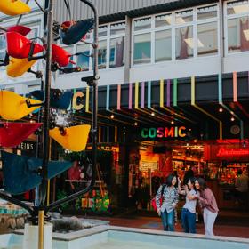 A group of people in Cuba Mall, looking at the Bucket Fountain, an iconic kinetic sculpture.