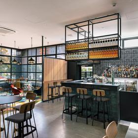 Wide view of bar in Atura Hotel, with seating around the bar.