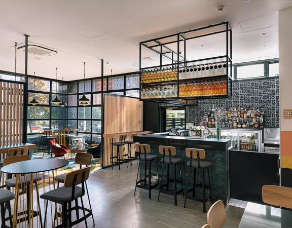 Wide view of bar in Atura Hotel, with seating around the bar.