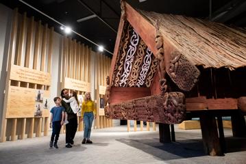 A family looks at the Nuku Tewhatewha inside Dowse Museum.